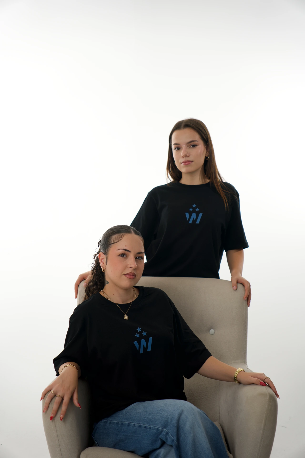 Dos modelos de la colección Winner posan con un sillón.