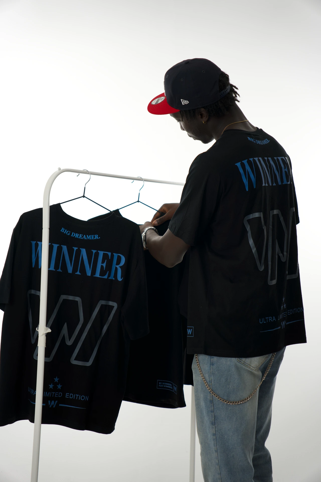 Modelo junto a un perchero con las camisetas Winner.